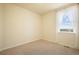 This bedroom features carpeted floors, a window with white curtains that provide natural light, and bare walls at 5584 Turnbury Cir, Elizabeth, CO 80107
