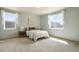 Bright bedroom with carpeted floors, two windows with natural light, and a double bed with decorative pillows at 5584 Turnbury Cir, Elizabeth, CO 80107