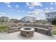 Backyard featuring a built-in stone fire pit with seating, offering a perfect spot for outdoor relaxation and entertainment at 5584 Turnbury Cir, Elizabeth, CO 80107