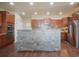 Spacious kitchen showcasing a stone-clad center island, granite countertops, and stainless steel appliances at 5584 Turnbury Cir, Elizabeth, CO 80107