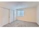 Bright bedroom featuring neutral carpet, a window with blinds, and a large closet with white doors at 18105 E Ohio Ave # 102, Aurora, CO 80017