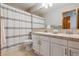 Bright bathroom with dual sinks, white cabinets and a shower/tub combo with striped curtain at 4247 Thistlesage Ct, Castle Rock, CO 80109