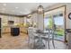 Well-lit kitchen and dining area with white cabinets, an island, and sliding glass door to the backyard at 4247 Thistlesage Ct, Castle Rock, CO 80109