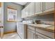 Functional laundry room with washer, dryer, sink, and storage cabinets for an organized space at 4247 Thistlesage Ct, Castle Rock, CO 80109