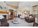 Open-concept living room featuring a cozy fireplace, wood floors, and views of the upper-level balcony at 4247 Thistlesage Ct, Castle Rock, CO 80109