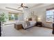 Spacious main bedroom showcasing tray ceilings, neutral decor and large windows providing ample natural light at 4247 Thistlesage Ct, Castle Rock, CO 80109