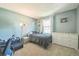 Serene bedroom with blue walls, soft lighting, and a window with views of the outdoors at 8150 W Calhoun Dr, Littleton, CO 80123