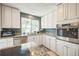 Bright kitchen featuring white cabinetry, granite countertops, and stainless steel appliances at 8150 W Calhoun Dr, Littleton, CO 80123