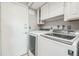 A conveniently located laundry room with modern washer and dryer units and built-in storage at 8150 W Calhoun Dr, Littleton, CO 80123