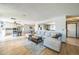 Open-concept living room with hardwood floors, a large sectional sofa, and seamless flow to the kitchen at 8150 W Calhoun Dr, Littleton, CO 80123