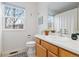 Bright bathroom with a window providing natural light, a wooden vanity, and patterned floors at 326 W Jamison Pl # 51, Littleton, CO 80120