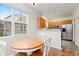 Bright breakfast nook features a round wood table, oak cabinets, and stainless steel appliances at 326 W Jamison Pl # 51, Littleton, CO 80120
