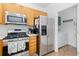 Modern kitchen with stainless steel refrigerator, gas range, and microwave above at 326 W Jamison Pl # 51, Littleton, CO 80120