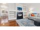Bright living room featuring a fireplace, built-in shelving, hardwood floors, and a comfortable seating area at 326 W Jamison Pl # 51, Littleton, CO 80120