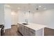 Modern kitchen with white quartz island and stainless steel appliances at 2571 W 69Th Pl, Denver, CO 80221