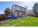 A spacious backyard with a large deck, patio furniture, and green grass at 10293 Rustic Redwood Ct, Highlands Ranch, CO 80126