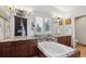 Bathroom boasts dual sinks, granite counters, soaking tub, and dark wood cabinetry at 10293 Rustic Redwood Ct, Highlands Ranch, CO 80126