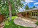 Lush backyard with mature trees, a patio area, and ample green space at 6550 E 6Th Avenue Pkwy, Denver, CO 80220