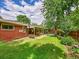 Lush green backyard with mature trees and patio, perfect for outdoor relaxation and entertaining at 6550 E 6Th Avenue Pkwy, Denver, CO 80220
