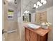 Updated bathroom with designer sink, mirrored wall, and tiled walls at 6550 E 6Th Avenue Pkwy, Denver, CO 80220