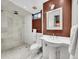 This bathroom has a tiled shower with a rainfall shower head, pedestal sink, and modern fixtures at 6550 E 6Th Avenue Pkwy, Denver, CO 80220