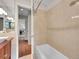 Bathroom view showing tub/shower with neutral tile and view into the sink area at 6550 E 6Th Avenue Pkwy, Denver, CO 80220