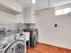 Efficient laundry room features modern washer and dryer, sink and white cabinets at 6550 E 6Th Avenue Pkwy, Denver, CO 80220