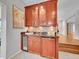 Stylish wet bar featuring cherry cabinets, granite counters, mosaic backsplash, and beverage fridge at 6550 E 6Th Avenue Pkwy, Denver, CO 80220