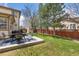 A lovely backyard features a patio with outdoor dining, a well-maintained lawn, and mature trees at 107 Prairie Falcon Pkwy, Brighton, CO 80601