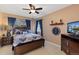 Cozy bedroom with a ceiling fan, a window with blue curtains, and a dark wood dresser and bed frame at 107 Prairie Falcon Pkwy, Brighton, CO 80601