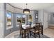 Bright dining room with neutral colors, a bay window, modern window treatments, and a chandelier at 107 Prairie Falcon Pkwy, Brighton, CO 80601