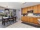Inviting kitchen and dining area with wood cabinets, tile flooring, and a window with decorative coverings at 107 Prairie Falcon Pkwy, Brighton, CO 80601