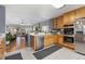 Modern kitchen with a breakfast bar, stainless steel appliances, and a view of the living room at 107 Prairie Falcon Pkwy, Brighton, CO 80601