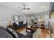 Cozy living room with hardwood floors, a ceiling fan, and a sliding door to the backyard at 107 Prairie Falcon Pkwy, Brighton, CO 80601