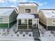 Tan and green two-story house with snow-covered front yard and steps at 739 Widgeon Cir, Longmont, CO 80503