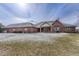 Expansive backyard view of a red brick house featuring large windows and covered patio at 14581 E Oberlin Pl, Aurora, CO 80014