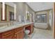 Elegant bathroom featuring double sinks, marble countertop, vanity area, soaking tub and natural light at 14581 E Oberlin Pl, Aurora, CO 80014