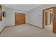 This carpeted bedroom boasts natural wood trim and closet with an additional door to the hallway at 14581 E Oberlin Pl, Aurora, CO 80014