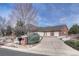 A spacious home featuring an attached four-car garage, brick exterior, and a long driveway at 14581 E Oberlin Pl, Aurora, CO 80014