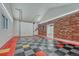 A modern garage with red brick and checkered flooring, and an entrance into the house at 14581 E Oberlin Pl, Aurora, CO 80014