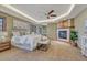 Comfortable primary bedroom featuring a cozy fireplace, ceiling fan, and soft neutral decor at 14581 E Oberlin Pl, Aurora, CO 80014