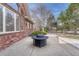 Brick home featuring outdoor patio with fire pit and view of the manicured landscape at 14581 E Oberlin Pl, Aurora, CO 80014