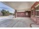 View of the large, covered patio featuring red brick columns and concrete flooring at 14581 E Oberlin Pl, Aurora, CO 80014