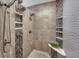 Walk-in shower featuring multiple shower heads, tile accents, and built-in shelving at 14581 E Oberlin Pl, Aurora, CO 80014