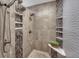 Modern tiled shower with rainfall shower head, handheld sprayer and built-in shelves at 14581 E Oberlin Pl, Aurora, CO 80014