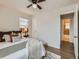 Bright bedroom showcasing hardwood floors, a ceiling fan, and a partial view into the bathroom at 3440 N Steele St, Denver, CO 80205