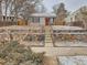 Charming home featuring a red front door and stone retaining wall and landscaped front yard with some snow at 3440 N Steele St, Denver, CO 80205