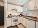 Clean kitchen with white appliances, white cabinets, a gas range, and bright natural light at 3440 N Steele St, Denver, CO 80205