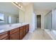 Bright bathroom with a double sink vanity, tile floors, separate tub, and glass enclosed shower at 16021 Verbena St, Brighton, CO 80602