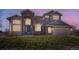 Dusk view of charming two-story home with brick facade, arched entryway, and illuminated windows at 16021 Verbena St, Brighton, CO 80602